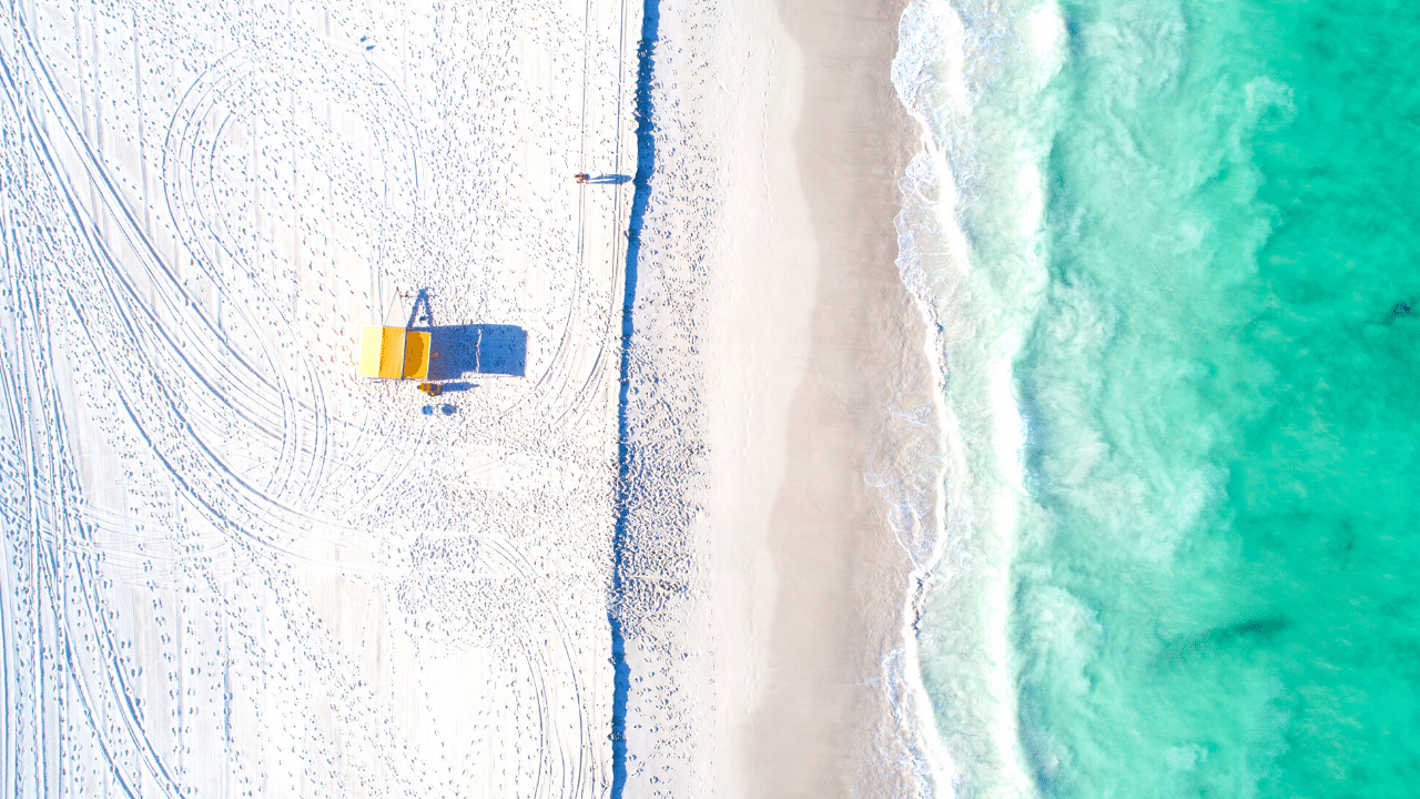 An aerial photo of a white beach and the ocean