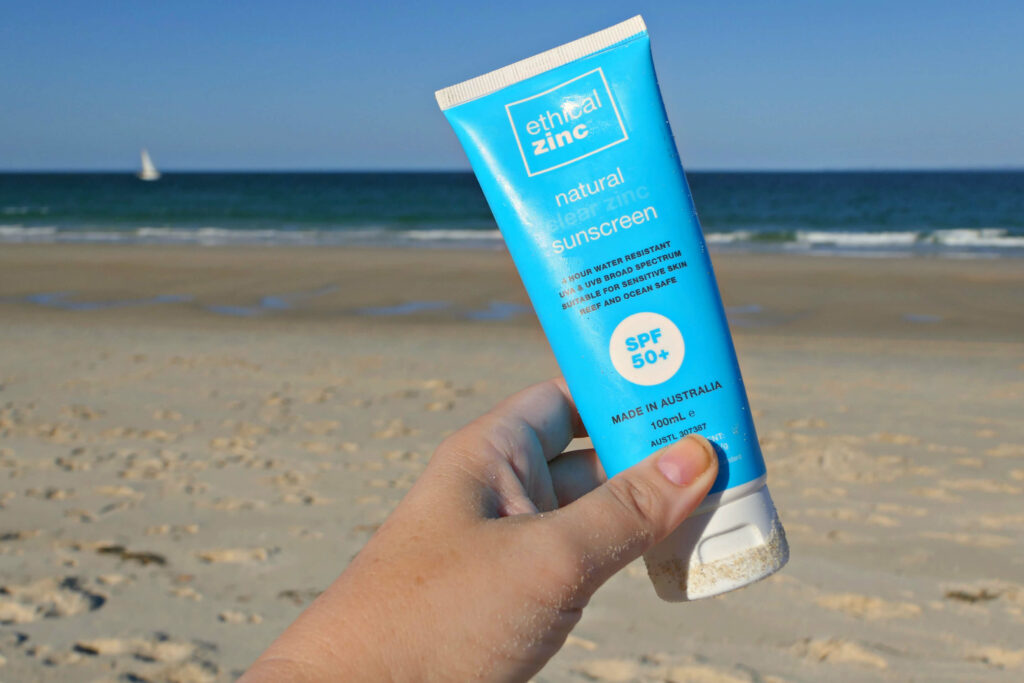 A bottle of Ethical zinc sunscreen Australia on a beach